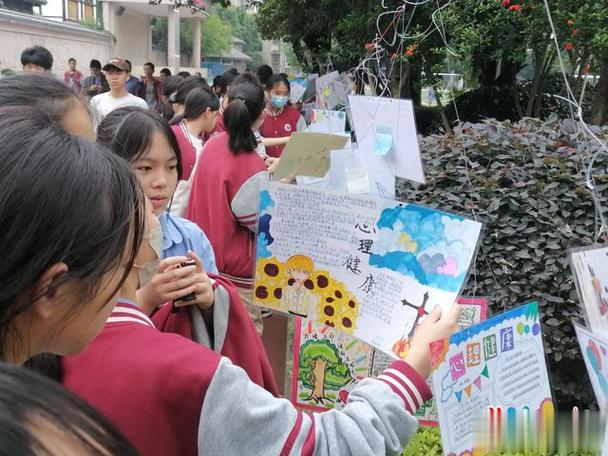 学生们课间围在一起在观看主题手抄报学生在宣传展板上写下心得感悟自